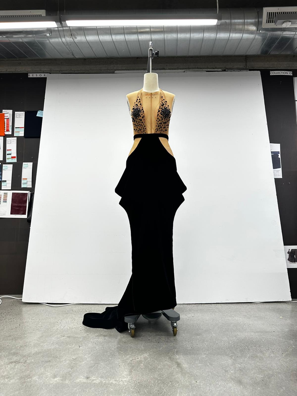 Black evening gown development on a dress form in a fashion studio