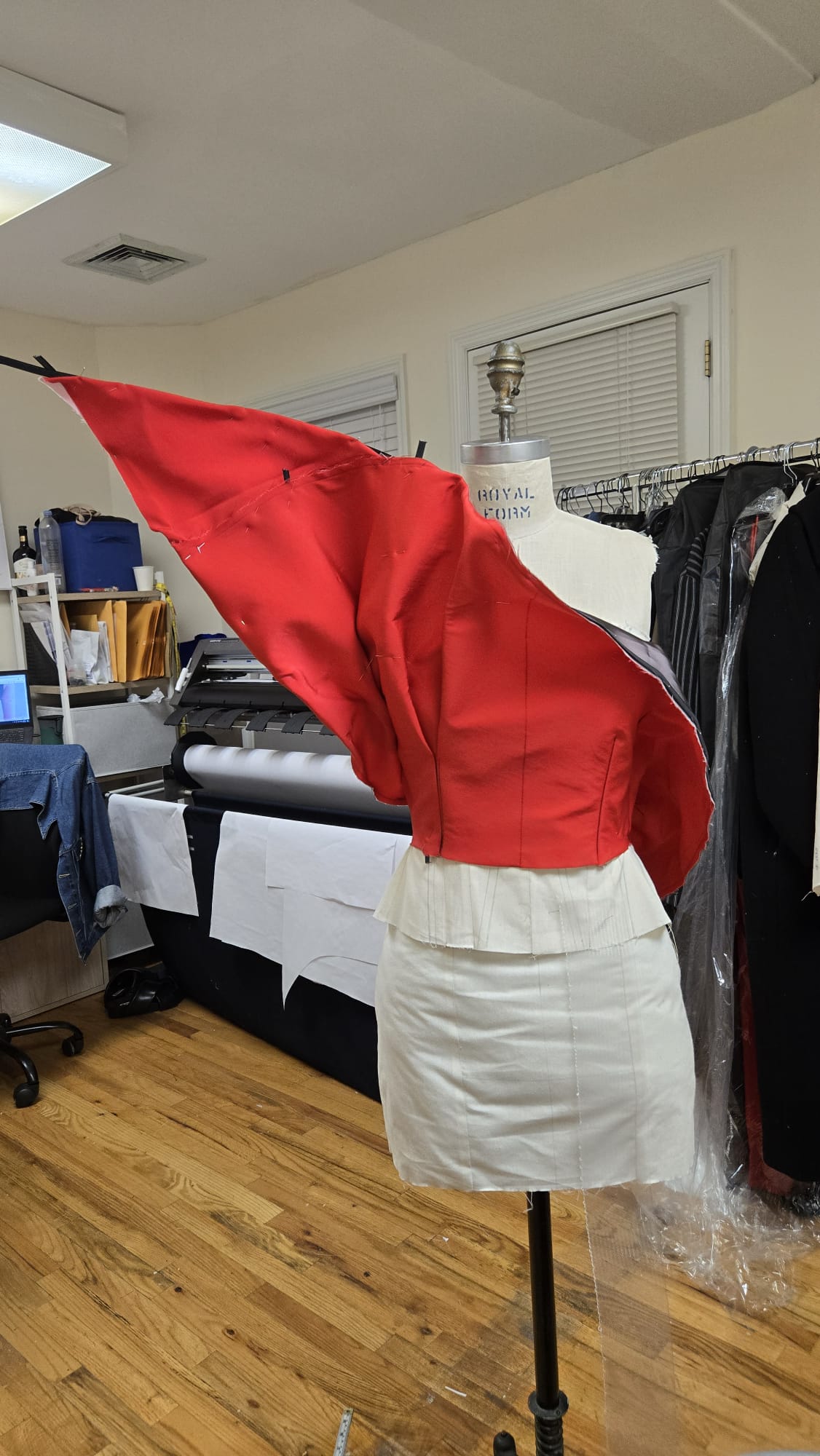 Red draped garment development on a dress form in the Pattern Atlas studio